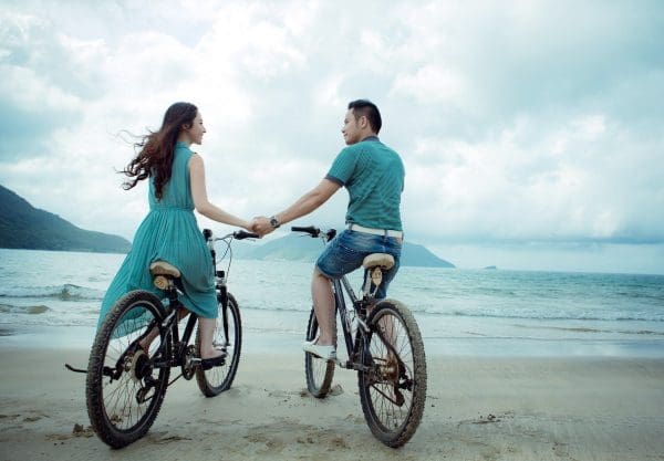 Couple heureux à vélo à la plage